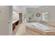Luxurious bathroom featuring a soaking tub, double vanity, and tiled accents at 1321 Ruby Way, Longmont, CO 80504