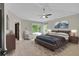 Serene bedroom with a ceiling fan, a comfortable bed, and a view of the greenery outside at 1321 Ruby Way, Longmont, CO 80504