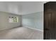 This carpeted bedroom has light green walls, a window to the outside, and a black door at 1321 Ruby Way, Longmont, CO 80504