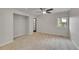 This bedroom boasts neutral carpeting, a window, a ceiling fan, and a black door to other rooms at 1321 Ruby Way, Longmont, CO 80504