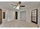 A well-lit bedroom with neutral carpet, a ceiling fan, a skylight and black doors at 1321 Ruby Way, Longmont, CO 80504