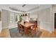 Elegant dining room with a modern chandelier, hardwood floors, and a large wooden table at 1321 Ruby Way, Longmont, CO 80504