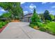 Attractive home exterior with a large driveway, well-maintained landscaping, and mature trees at 1321 Ruby Way, Longmont, CO 80504