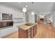 Bright kitchen featuring white cabinets, an island with granite countertops, and an open living space with fireplace at 1321 Ruby Way, Longmont, CO 80504