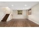 Inviting finished basement area with wood-look flooring, a staircase, and a window offering natural light at 6721 Quay Ct, Arvada, CO 80003