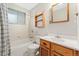 Cozy bathroom with a white vanity, a wooden framed mirror, and a bathtub with a shower at 6721 Quay Ct, Arvada, CO 80003