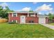 Charming red brick home with well-maintained lawn and attached one car garage at 6721 Quay Ct, Arvada, CO 80003