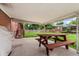 Covered patio area with a red picnic table overlooking the backyard at 6721 Quay Ct, Arvada, CO 80003