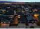 Expansive aerial view of a neighborhood featuring well-maintained homes and spacious driveways, with city lights in the distance at 9446 E 51St Dr, Denver, CO 80238