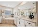 Serene bathroom with a soaking tub, granite countertops, and double sinks at 9446 E 51St Dr, Denver, CO 80238