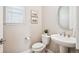 Stylish half-bathroom with a pedestal sink, modern fixtures, and neutral color scheme at 9446 E 51St Dr, Denver, CO 80238
