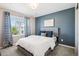 Cozy bedroom with blue accent wall, soft carpet, and a bright window at 9446 E 51St Dr, Denver, CO 80238
