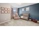 Bedroom with large windows, a comfortable chair, and a crib at 9446 E 51St Dr, Denver, CO 80238