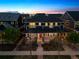 Stunning aerial view of a home with a well-manicured lawn, inviting front porch, and picturesque sunset backdrop at 9446 E 51St Dr, Denver, CO 80238