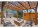 Outdoor fire pit area with stone patio and surrounding seating under a wood pergola, perfect for entertaining at 9446 E 51St Dr, Denver, CO 80238