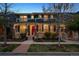 Charming two-story home featuring a welcoming front porch with beautiful landscaping and a striking red front door at 9446 E 51St Dr, Denver, CO 80238
