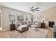 Cozy living room featuring a comfortable sectional sofa, fireplace, and large windows for ample natural light at 9446 E 51St Dr, Denver, CO 80238