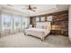 Spacious main bedroom with a tray ceiling, a wood accent wall, and lots of natural light at 9446 E 51St Dr, Denver, CO 80238