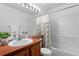 Clean bathroom with a wooden vanity, decorative shower curtain, and bright vanity lighting at 14247 Pikeminnow Pl, Broomfield, CO 80023