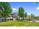 Charming townhouse with a white picket fence, lush lawn, mature trees, and a gazebo in the common area at 14247 Pikeminnow Pl, Broomfield, CO 80023