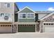 Townhome with attached garages and stone accents, set against a blue sky backdrop at 14247 Pikeminnow Pl, Broomfield, CO 80023