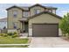 Two-story home with green siding, a dark brown garage door, and well-maintained landscaping at 4280 Pioneer Pl, Brighton, CO 80601