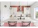Modern kitchen features white cabinets, an island with seating, and stylish black pendant lights at 4280 Pioneer Pl, Brighton, CO 80601