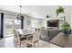 Bright open-concept living room with modern lighting, neutral tones, and sliding glass doors to the backyard at 4280 Pioneer Pl, Brighton, CO 80601