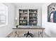 Stylish home office featuring a modern desk, rolling chair, built-in bookshelves, and natural light at 4280 Pioneer Pl, Brighton, CO 80601