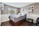 Comfortable bedroom with a cozy bed, natural light from the window, and decorative shelving on the wall at 9624 Crosspointe Dr, Highlands Ranch, CO 80130