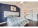 Cozy bedroom featuring a modern ceiling fan, stylish decor, and a comfortable bed against a blue accent wall at 9624 Crosspointe Dr, Highlands Ranch, CO 80130