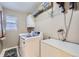 Laundry room with front load washer and dryer, storage and window at 9624 Crosspointe Dr, Highlands Ranch, CO 80130