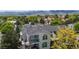 Scenic view of a multi-story home with private balconies amidst lush greenery and mountain backdrop at 1670 S Deframe St # C2, Lakewood, CO 80228