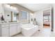 Bright and spacious bathroom with a soaking tub, double vanity, and modern fixtures at 11829 Deorio St, Parker, CO 80134