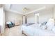 Bright and airy main bedroom featuring neutral walls, chair, dresser, and tray ceiling at 11829 Deorio St, Parker, CO 80134