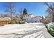 Snowy backyard with a two-story house and wooden fence at 17009 E Loyola Pl, Aurora, CO 80013