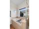 Bathroom with tile-surrounded tub, silver fixtures, glass shower and a window bringing in natural light at 4511 Perry St, Denver, CO 80212