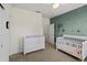 Bedroom with green accent wall, closet, and white furniture set with changing table and crib at 4511 Perry St, Denver, CO 80212