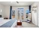 Bright bedroom featuring a ceiling fan, large windows, and elegant decor with hardwood floors at 4511 Perry St, Denver, CO 80212