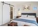 Bedroom featuring a ceiling fan, large windows, elegant decor, and a barn door to the bathroom at 4511 Perry St, Denver, CO 80212