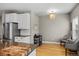 A dining area with stainless steel refrigerator, granite countertops, hardwood floors and comfortable seating at 4511 Perry St, Denver, CO 80212