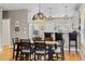 Open-concept dining area with a stylish dining table and kitchen bar seating at 4511 Perry St, Denver, CO 80212