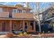 Inviting brick home featuring a cozy front porch and manicured landscaping at 4511 Perry St, Denver, CO 80212