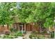 Well-maintained brick home with lush front yard landscaping and mature trees at 4511 Perry St, Denver, CO 80212