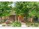 Charming brick home with lush landscaping, mature trees, and inviting front porch at 4511 Perry St, Denver, CO 80212