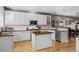 Bright kitchen with stainless steel appliances, white cabinets, granite counters and a center island at 4511 Perry St, Denver, CO 80212