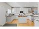 Spacious kitchen featuring white cabinets, granite countertops, stainless steel appliances, and a center island at 4511 Perry St, Denver, CO 80212