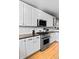 Stylish kitchen with stainless steel appliances, white cabinets, and hardwood floors at 4511 Perry St, Denver, CO 80212
