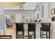 A kitchen with three black barstools in front of a granite countertop, white cabinets and stainless steel appliances at 4511 Perry St, Denver, CO 80212