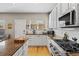 Bright kitchen with stainless steel appliances, granite countertops, white cabinets, and hardwood floors at 4511 Perry St, Denver, CO 80212